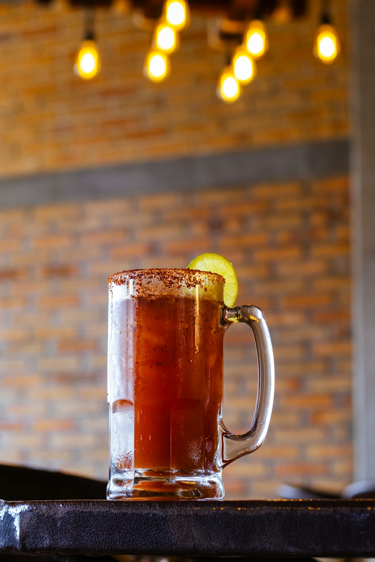 Fotografía real de una michelada escarchada con limón